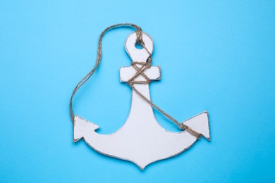 White wooden anchor figure on light blue background, top view