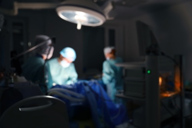 Photo of Blurred view of medical team performing surgery in operating room