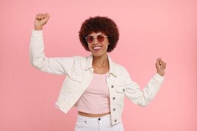 Photo of Happy young woman dancing on pink background