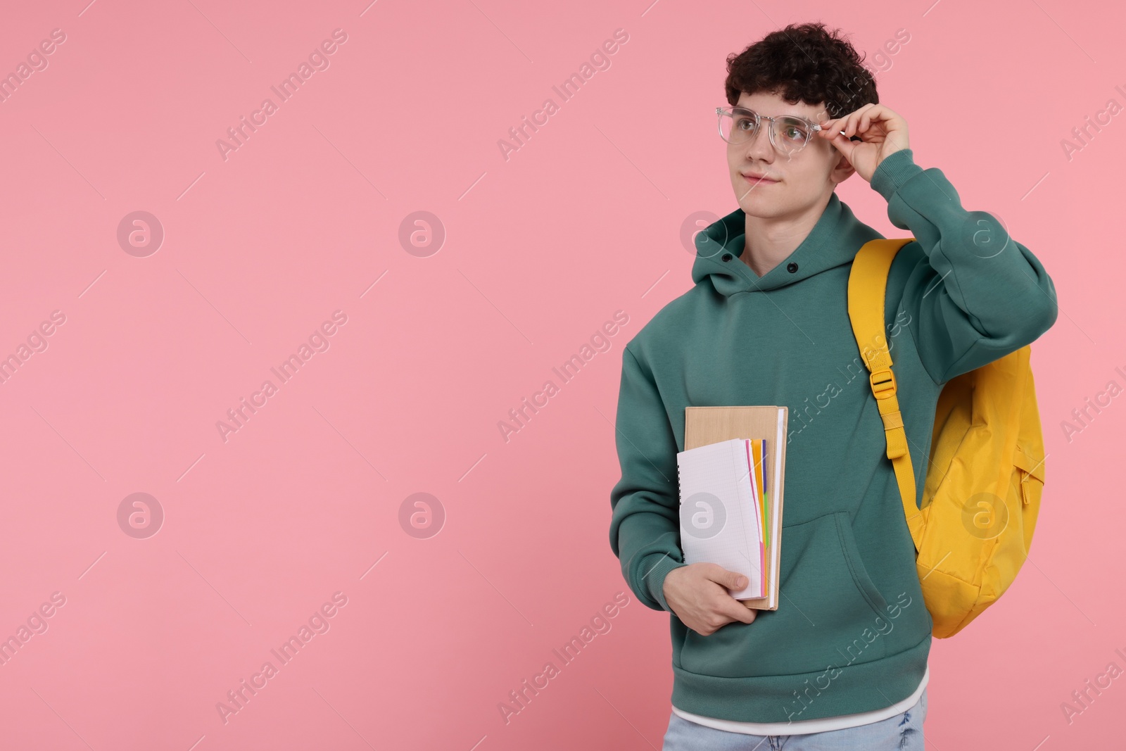 Photo of Portrait of student with backpack and notebooks on pink background. Space for text