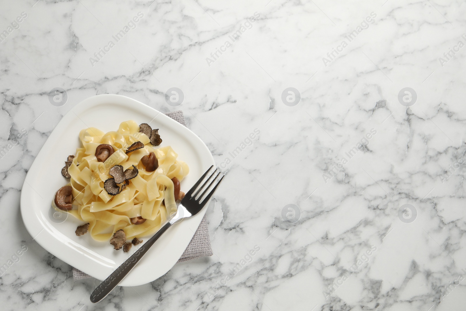Photo of Tasty tagliatelle with truffle on table, top view. Space for text
