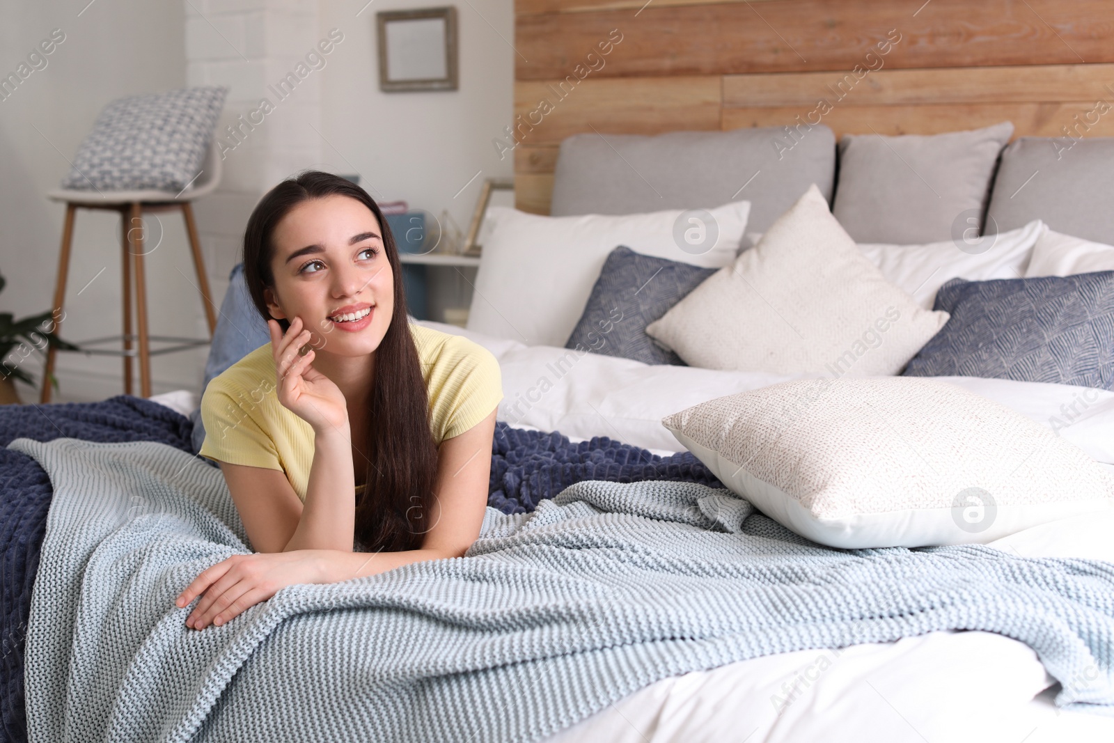 Photo of Woman lying on bed in modern room. Elegant interior