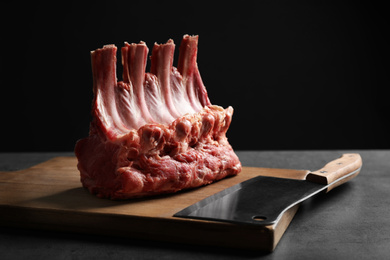 Raw ribs on grey table against black background