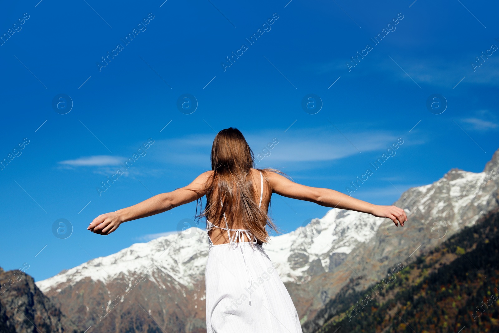 Photo of Young woman walking in beautiful mountains on sunny day