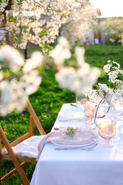 Photo of Stylish table setting with beautiful spring flowers in garden