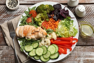 Photo of Balanced diet and healthy foods. Plate with different delicious products on wooden table, flat lay