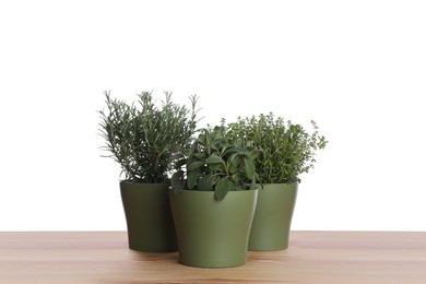 Photo of Pots with thyme, sage and rosemary on wooden table against white background
