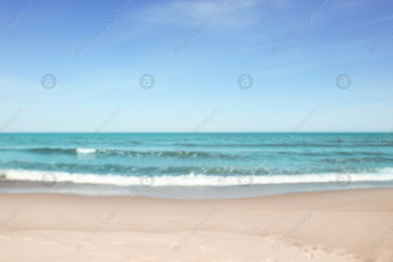 Photo of Blurred view of beautiful sea and sandy beach on sunny day