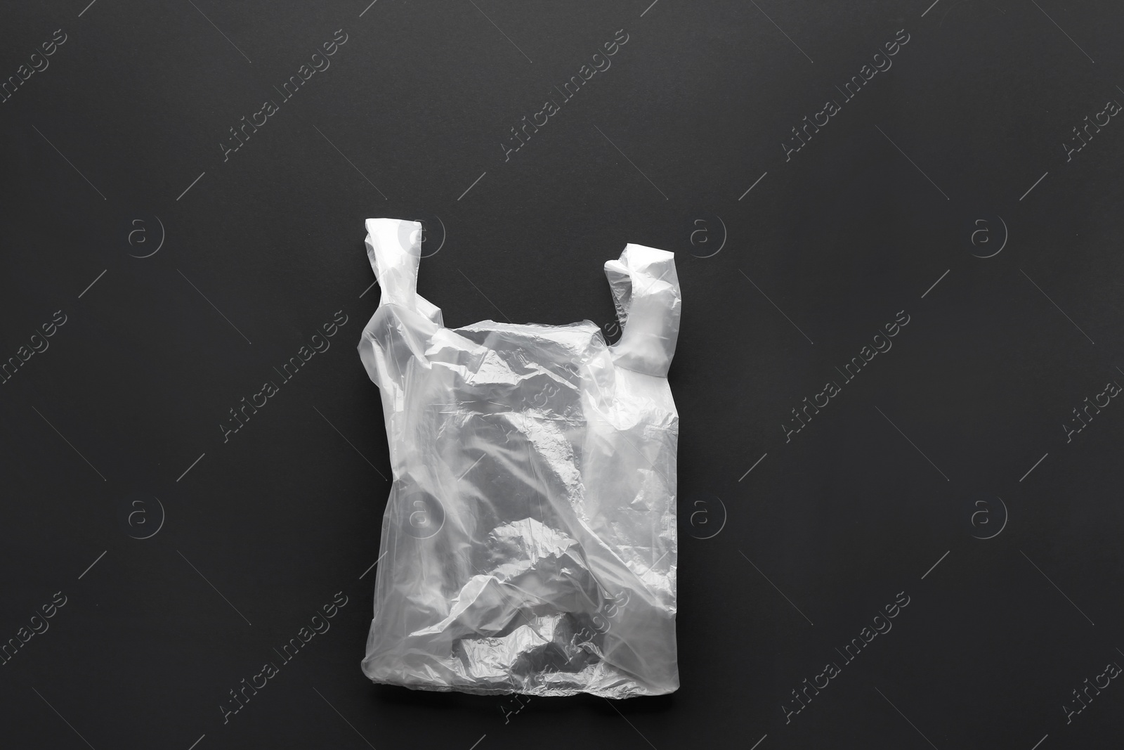 Photo of Clear disposable plastic bag on black background