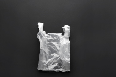 Photo of Clear disposable plastic bag on black background