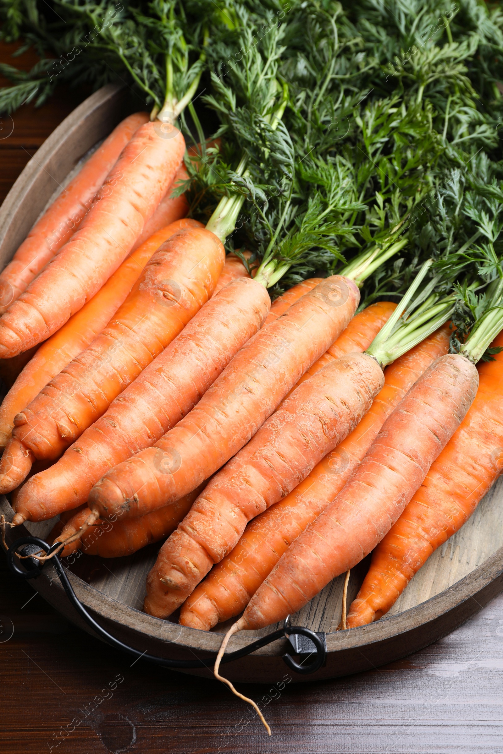 Photo of Many tasty fresh carrots on wooden table