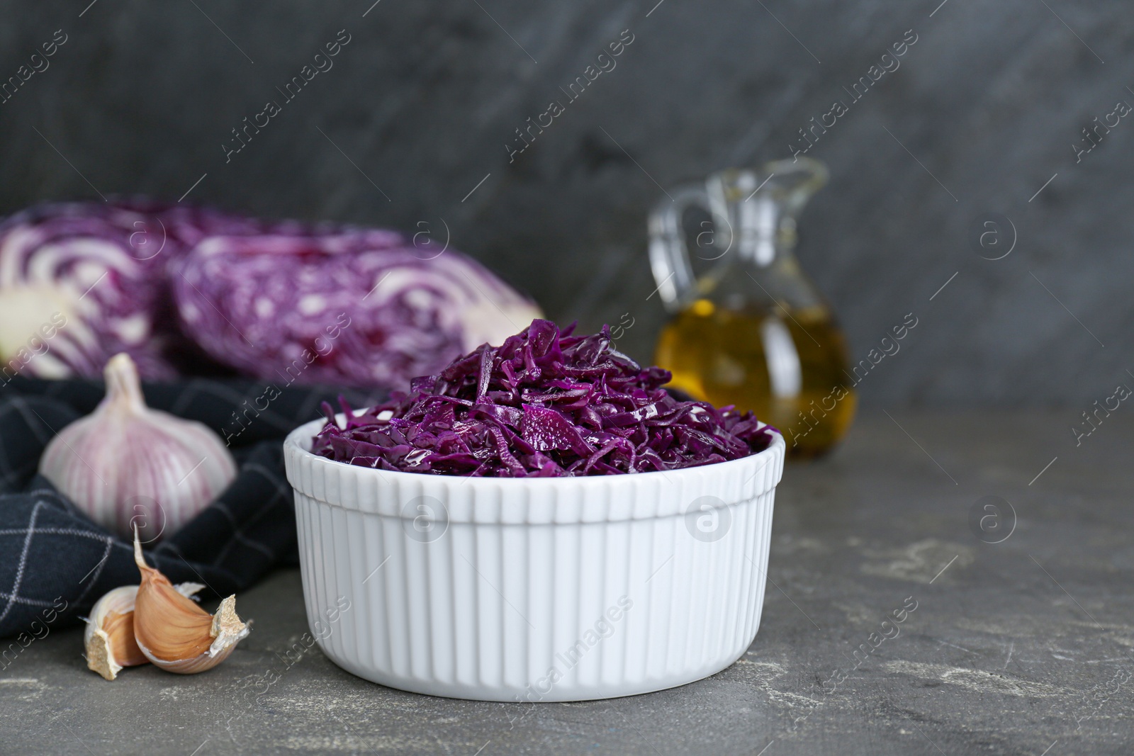 Photo of Tasty red cabbage sauerkraut and different ingredients on light grey table. Space for text