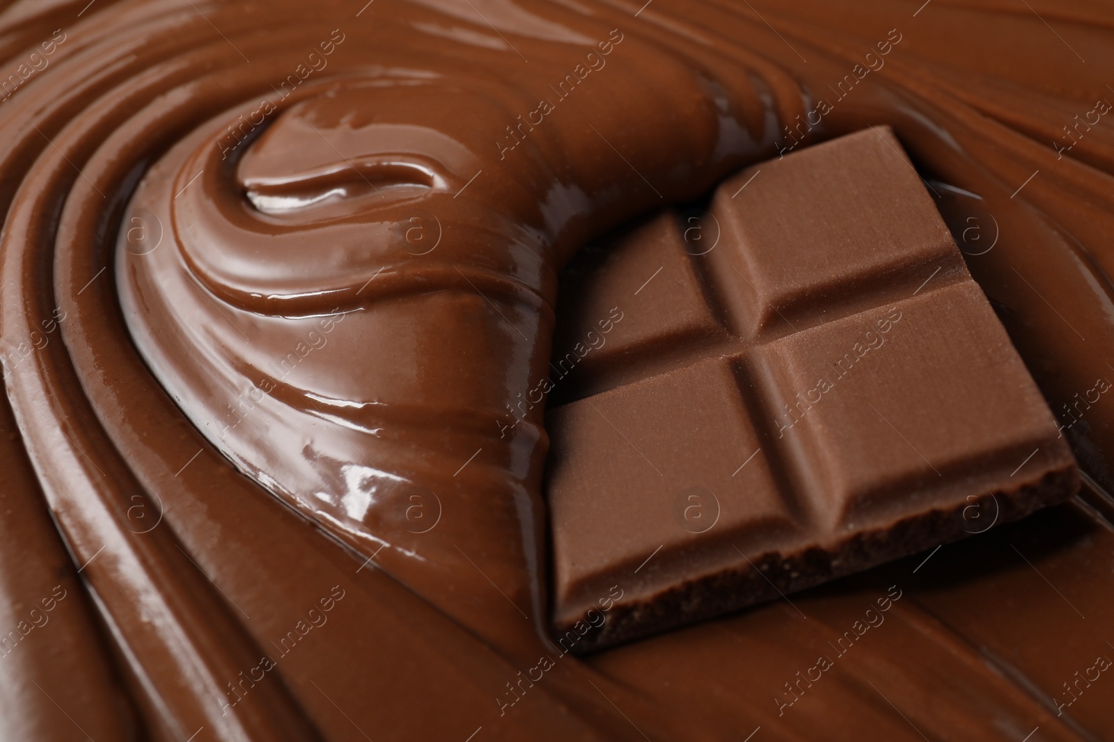 Photo of Tasty milk chocolate paste and pieces as background, closeup