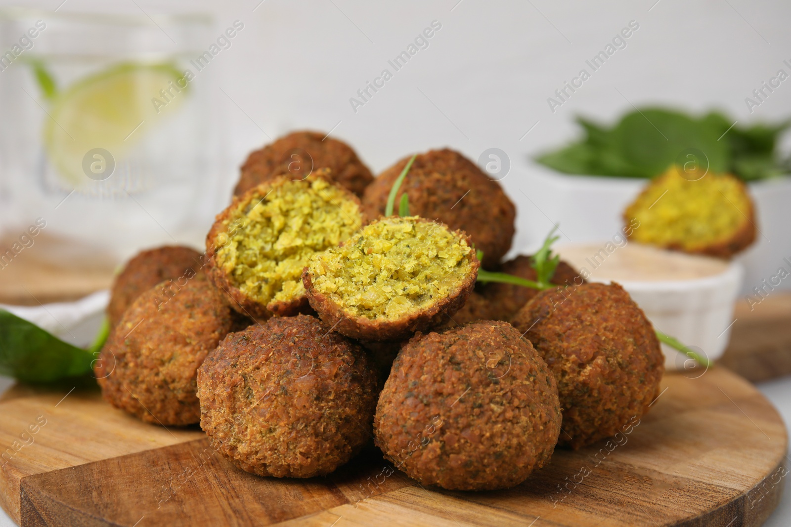 Photo of Delicious falafel balls on wooden board, closeup