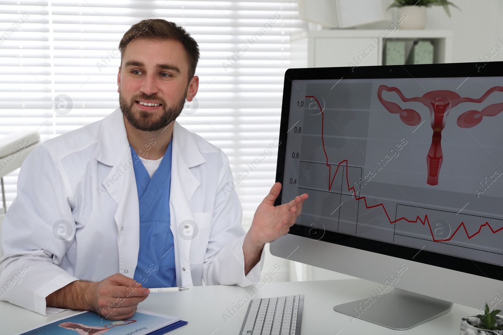 Photo of Gynecologist demonstrating picture of female reproductive system on screen in clinic