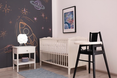 Photo of Stylish baby room interior with comfortable bed