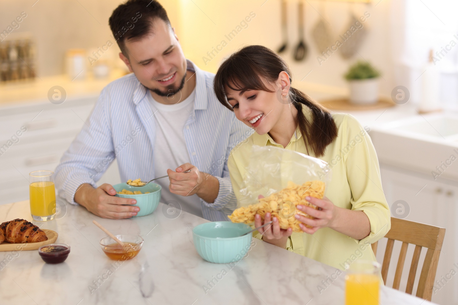 Photo of Happy couple having tasty breakfast at home