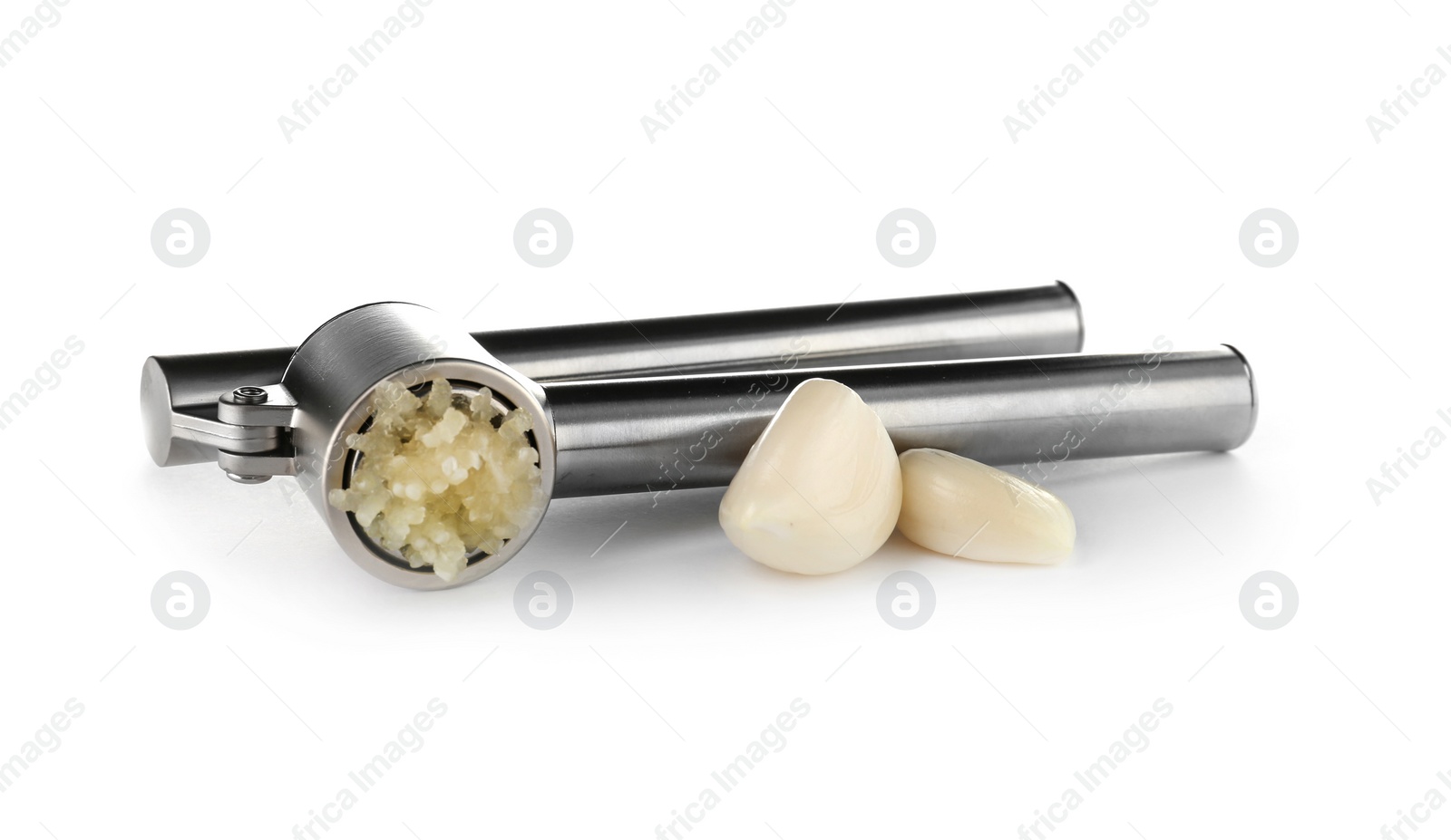 Photo of Garlic press and cloves on white background. Kitchen utensil