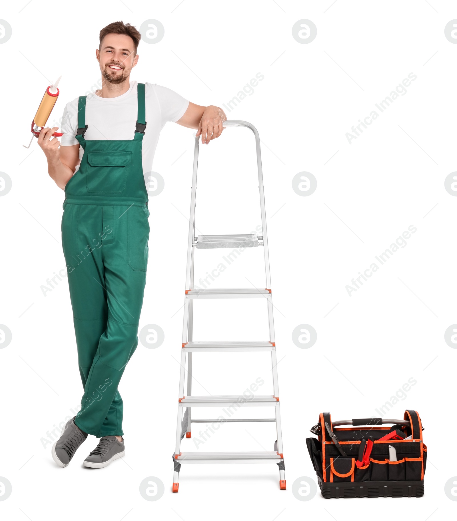 Photo of Worker with mounting adhesive near metal ladder on white background