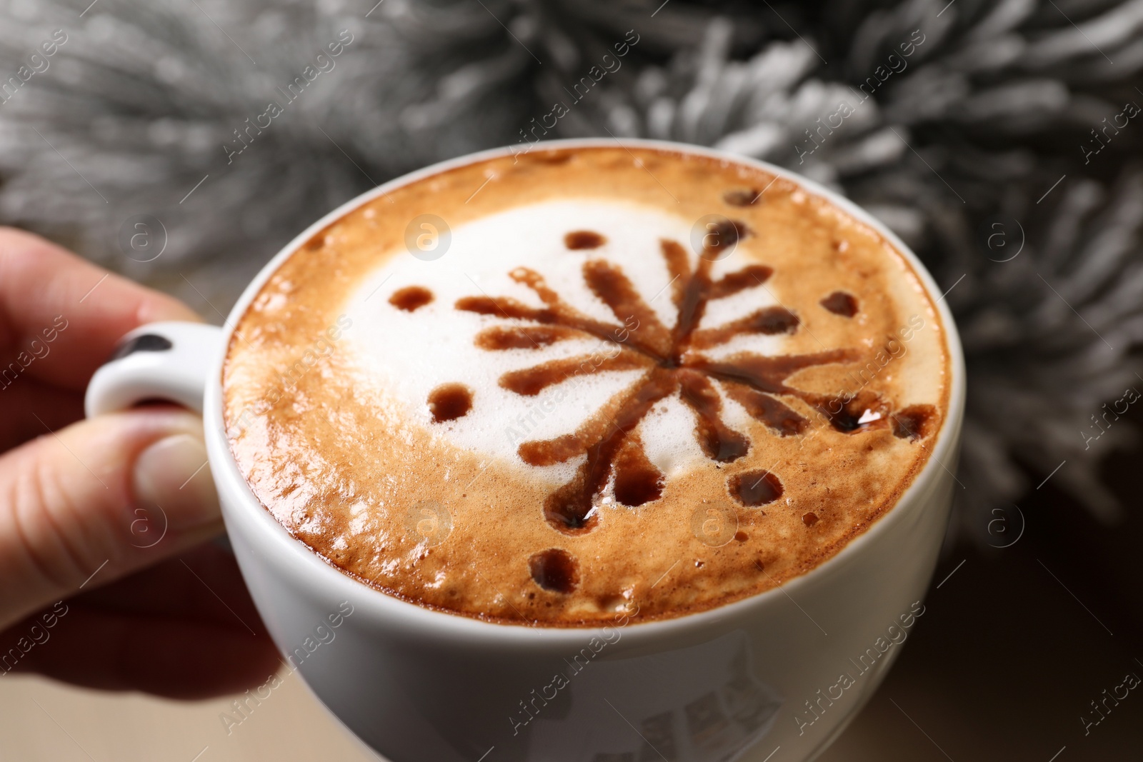 Photo of Woman holding cup of aromatic coffee near fir branch, closeup