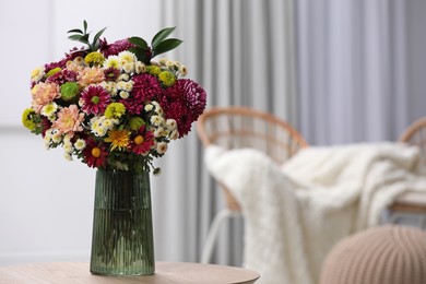 Photo of Bouquet of beautiful chrysanthemum flowers on table in room, space for text