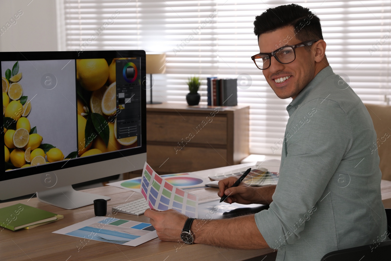 Photo of Professional retoucher working on computer in office