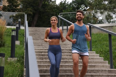Photo of Healthy lifestyle. Happy couple running down stairs outdoors