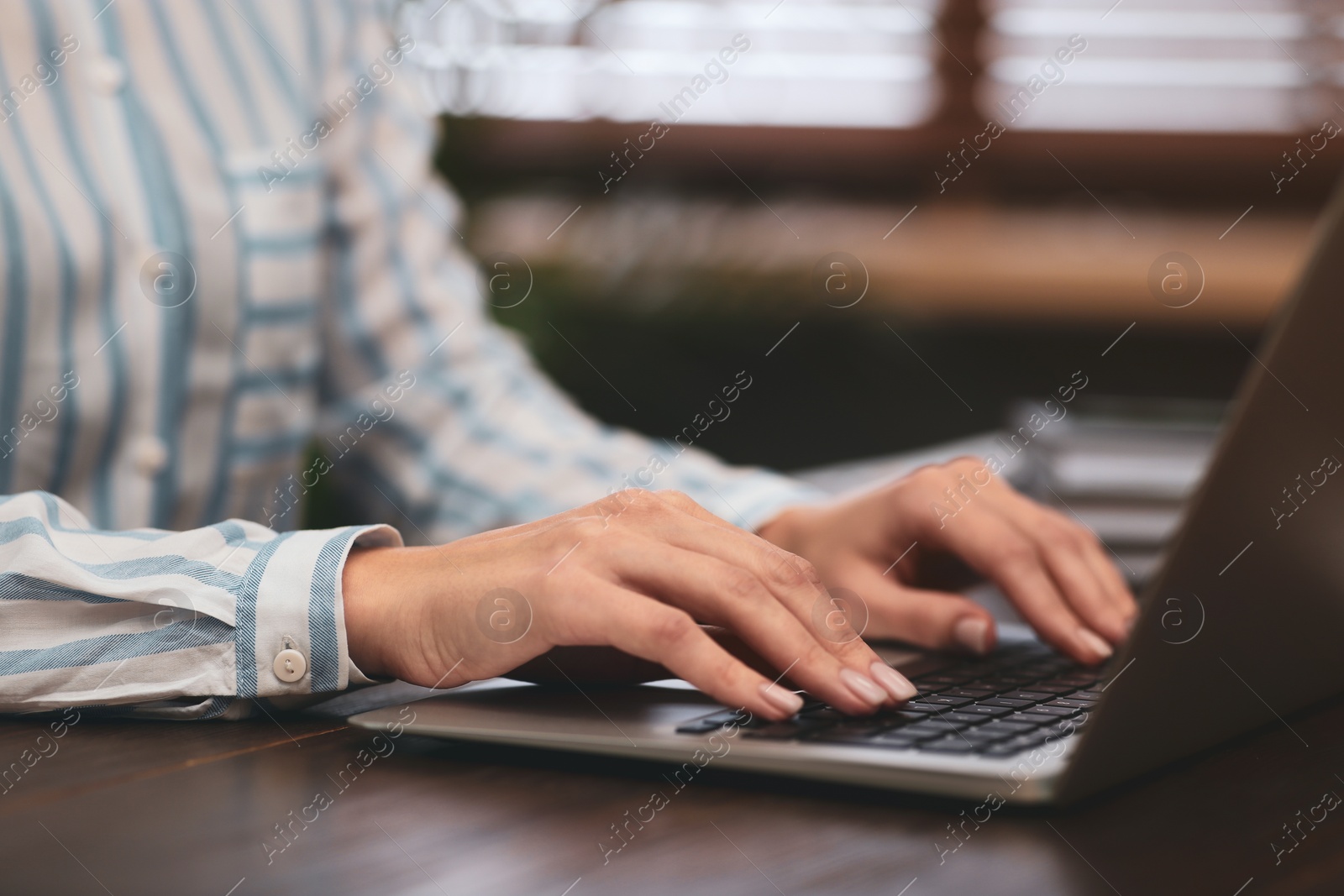 Photo of Woman working on modern laptop at table, closeup