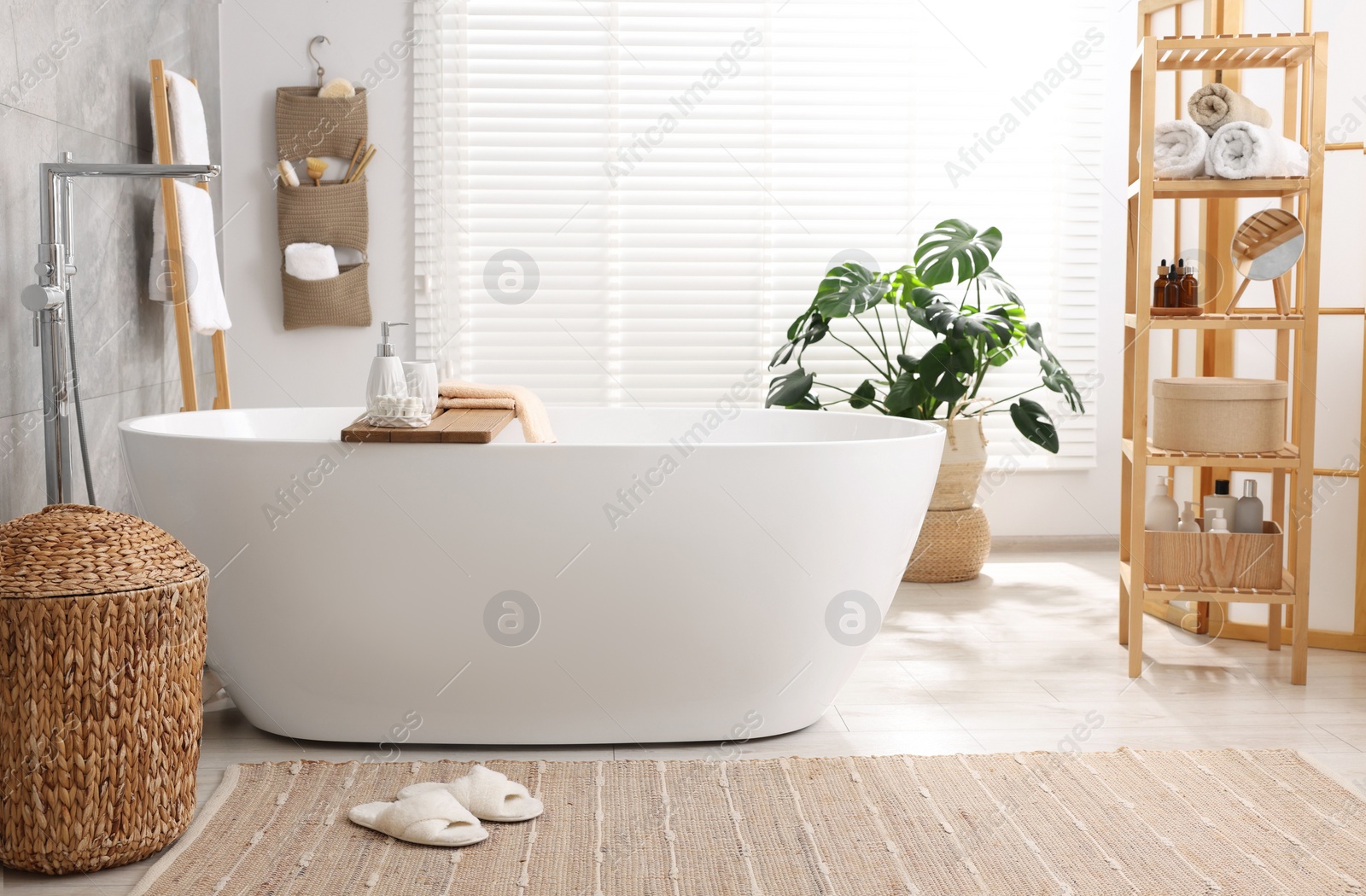 Photo of Set of different bath accessories and soap on tub in bathroom