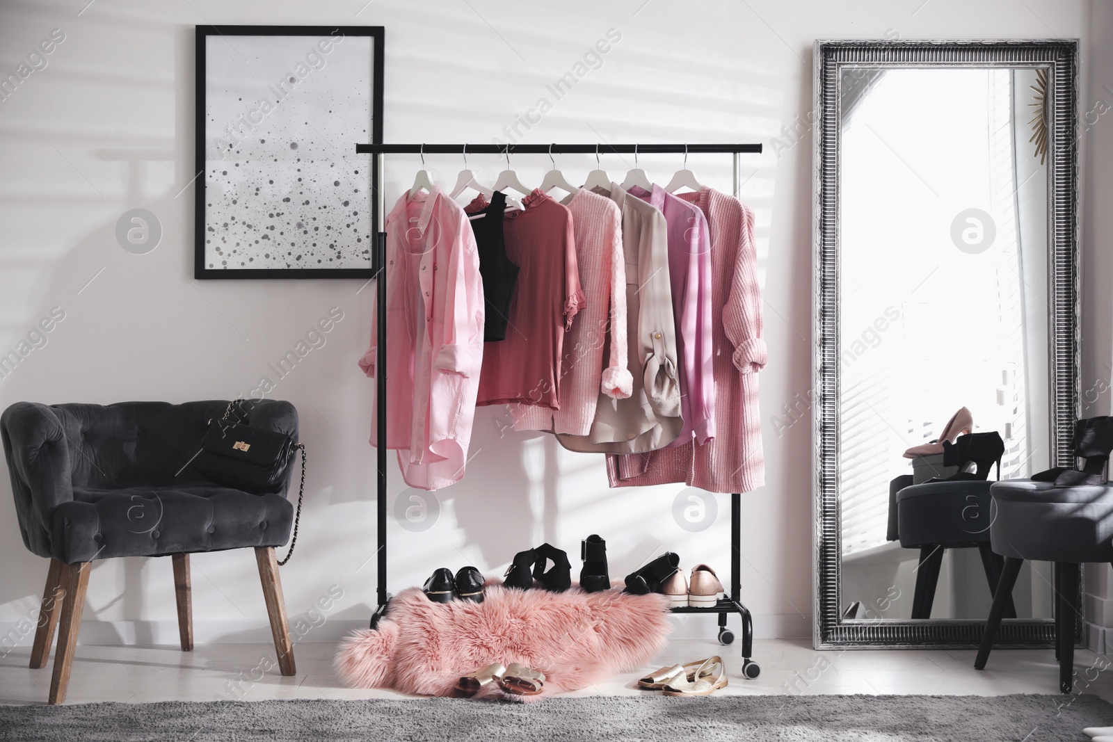 Photo of Dressing room interior with clothing rack and comfortable chair