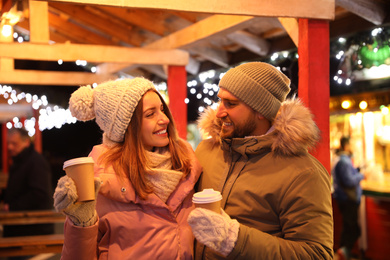 Photo of Happy couple with drinks at Christmas fair
