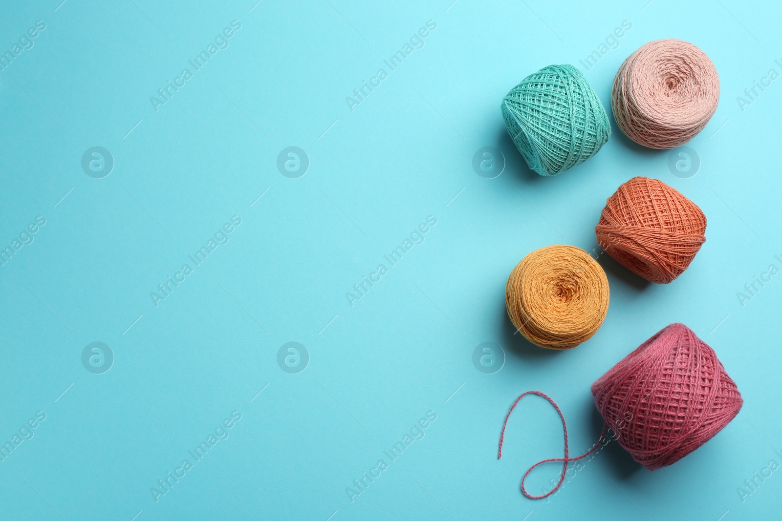 Photo of Clews of knitting threads on color background, flat lay with space for text. Sewing stuff