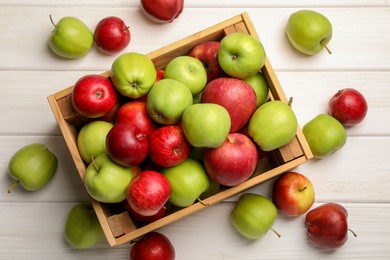 Fresh ripe red and green apples on white wooden table, flat lay