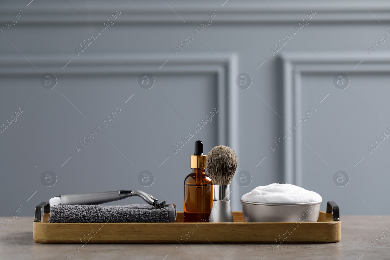 Photo of Set of men's shaving tools in wooden tray on grey table