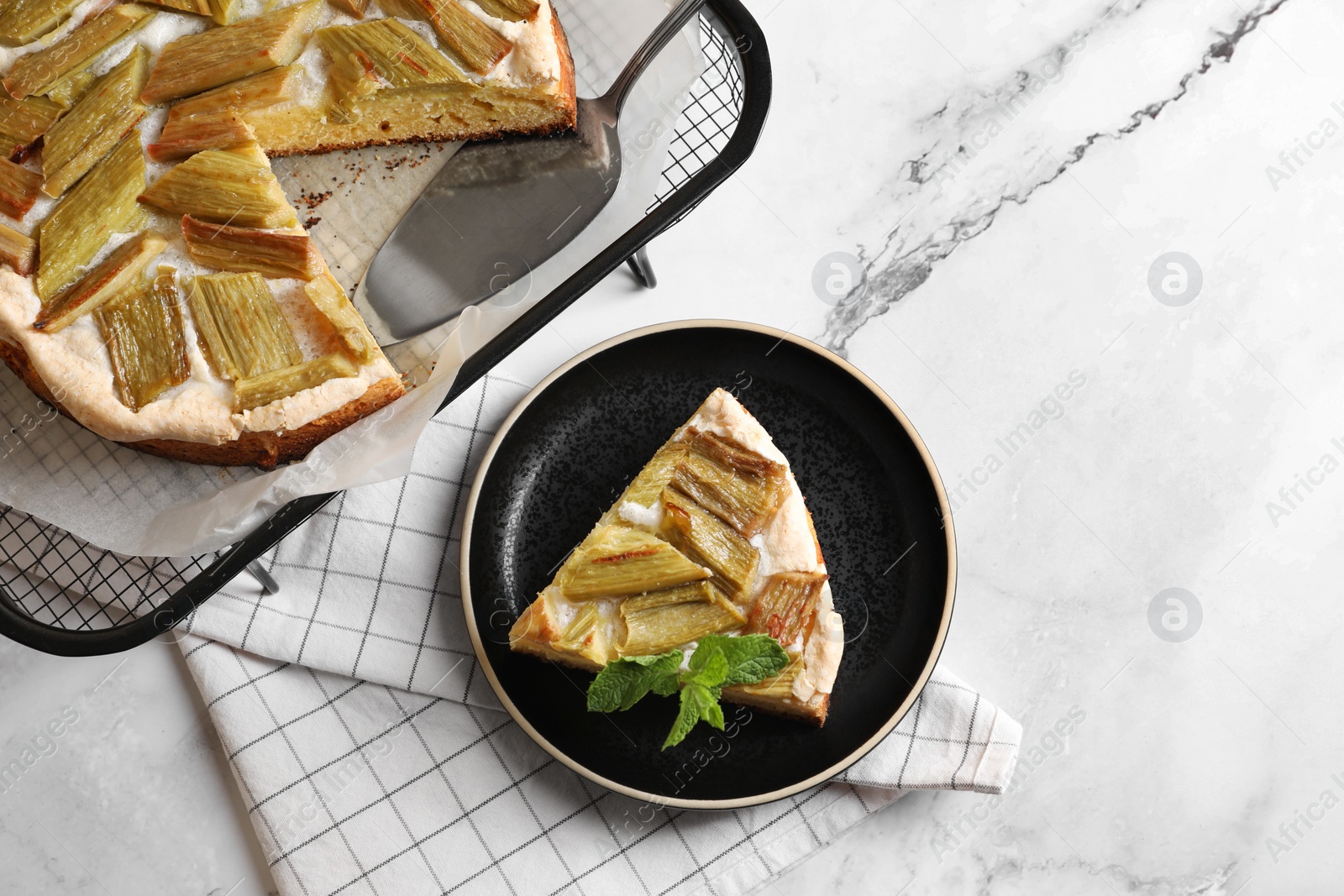 Photo of Freshly baked rhubarb pie and cake server on white marble table, flat lay