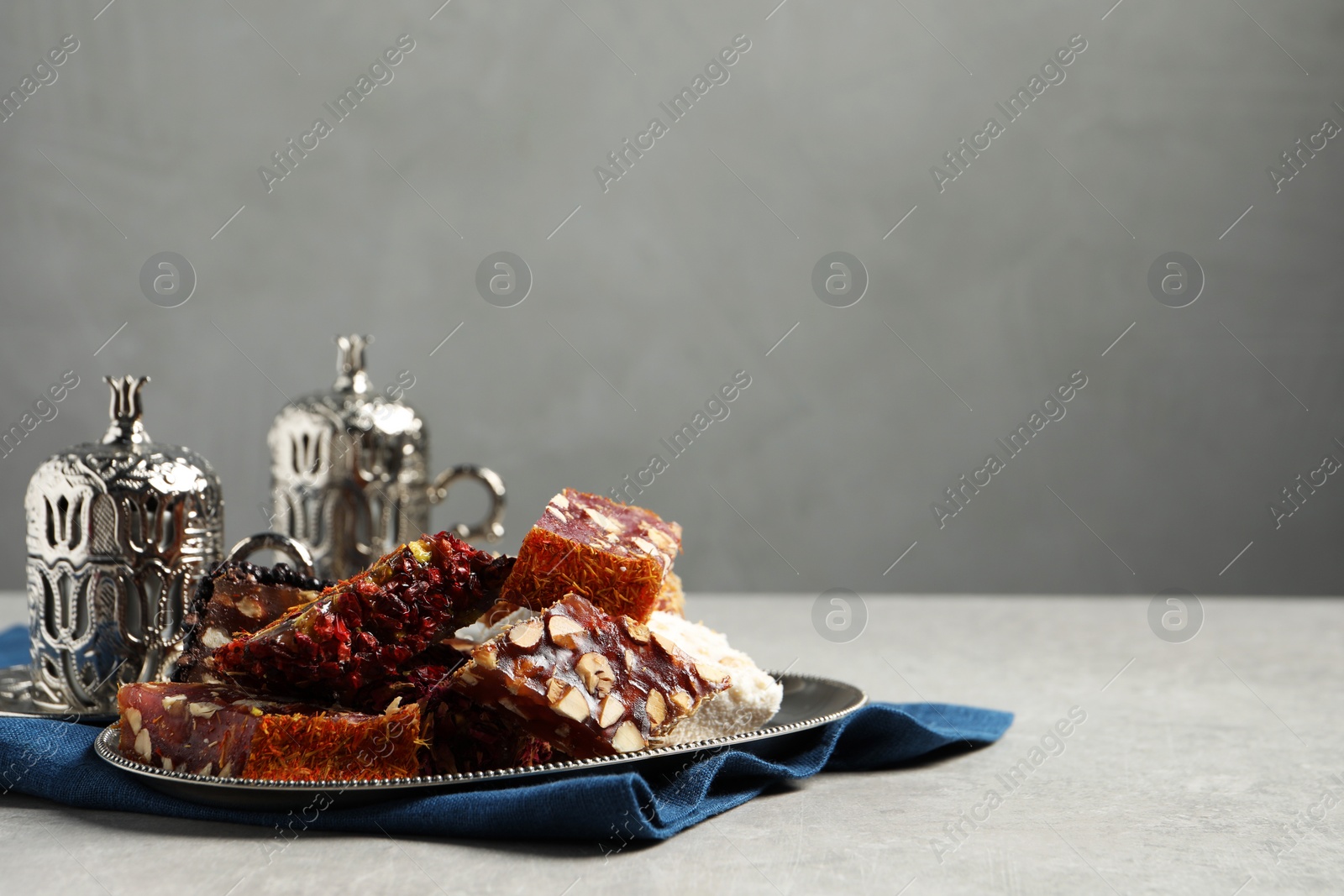 Photo of Tea and Turkish delight served in vintage tea set on grey table, space for text