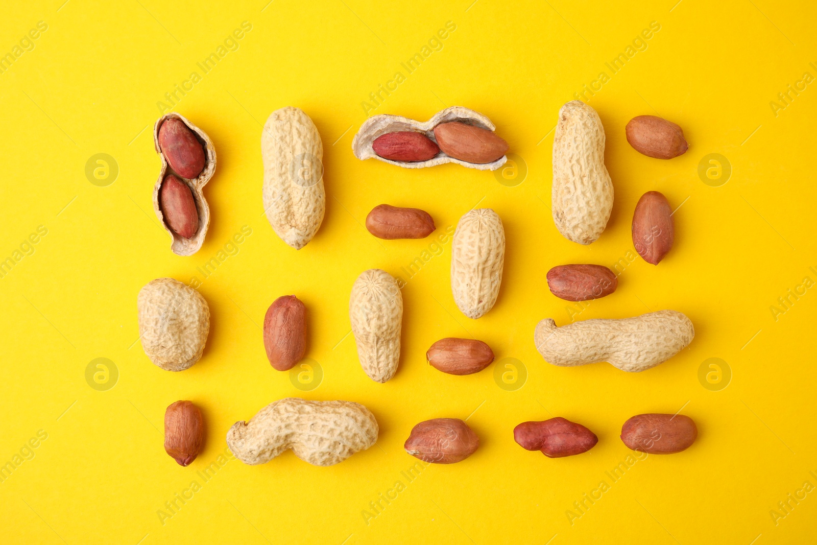 Photo of Fresh peanuts on yellow table, flat lay