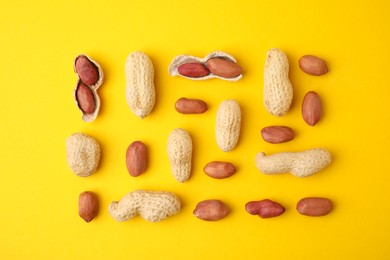 Photo of Fresh peanuts on yellow table, flat lay