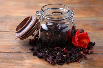 Photo of Dry hibiscus tea and flower on wooden table