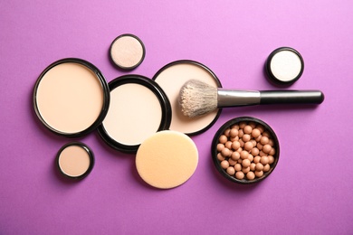 Flat lay composition with various makeup face powders on color background