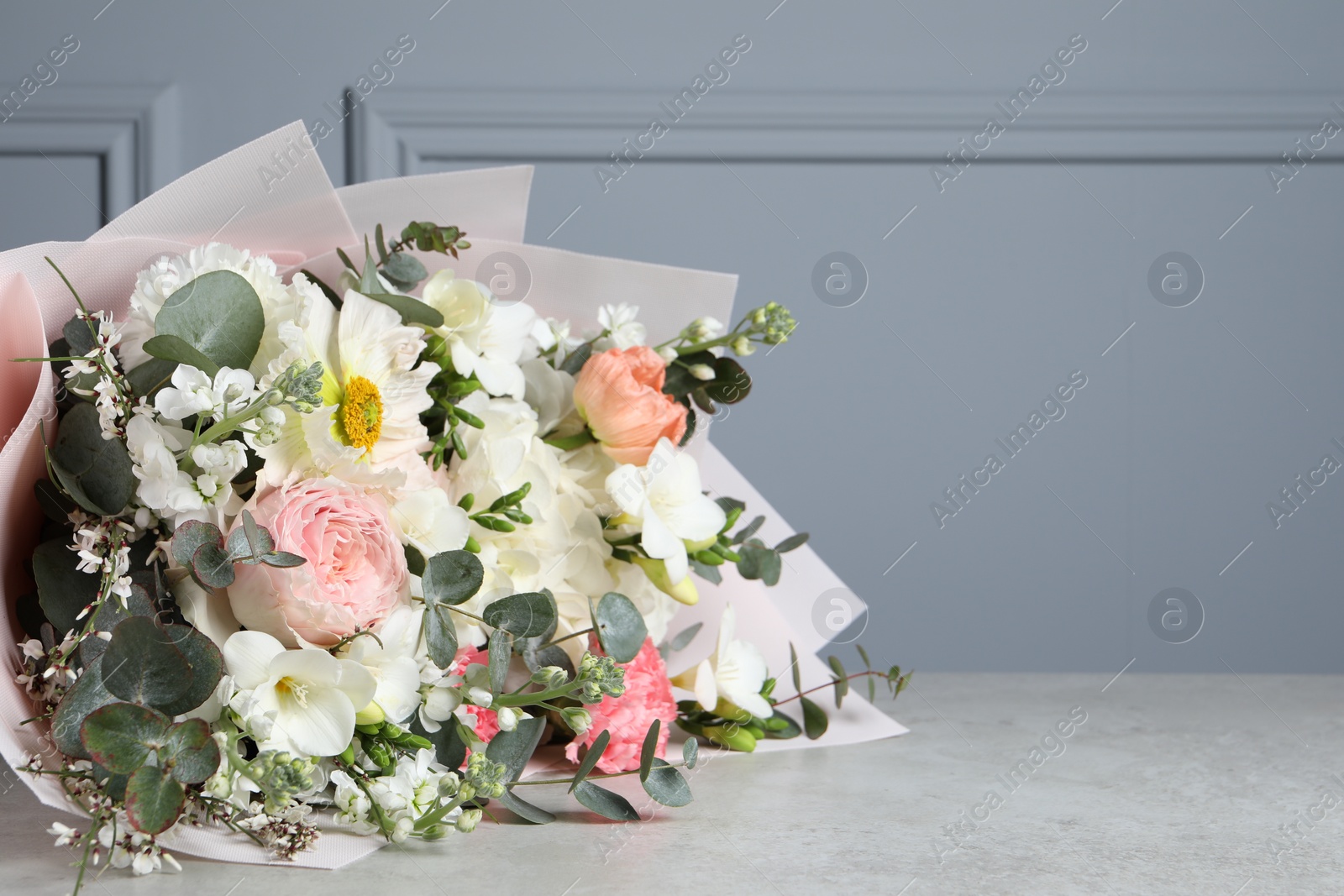 Photo of Bouquet of beautiful flowers on light grey table, closeup. Space for text