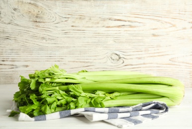 Fresh ripe green celery on white wooden table. Space for text