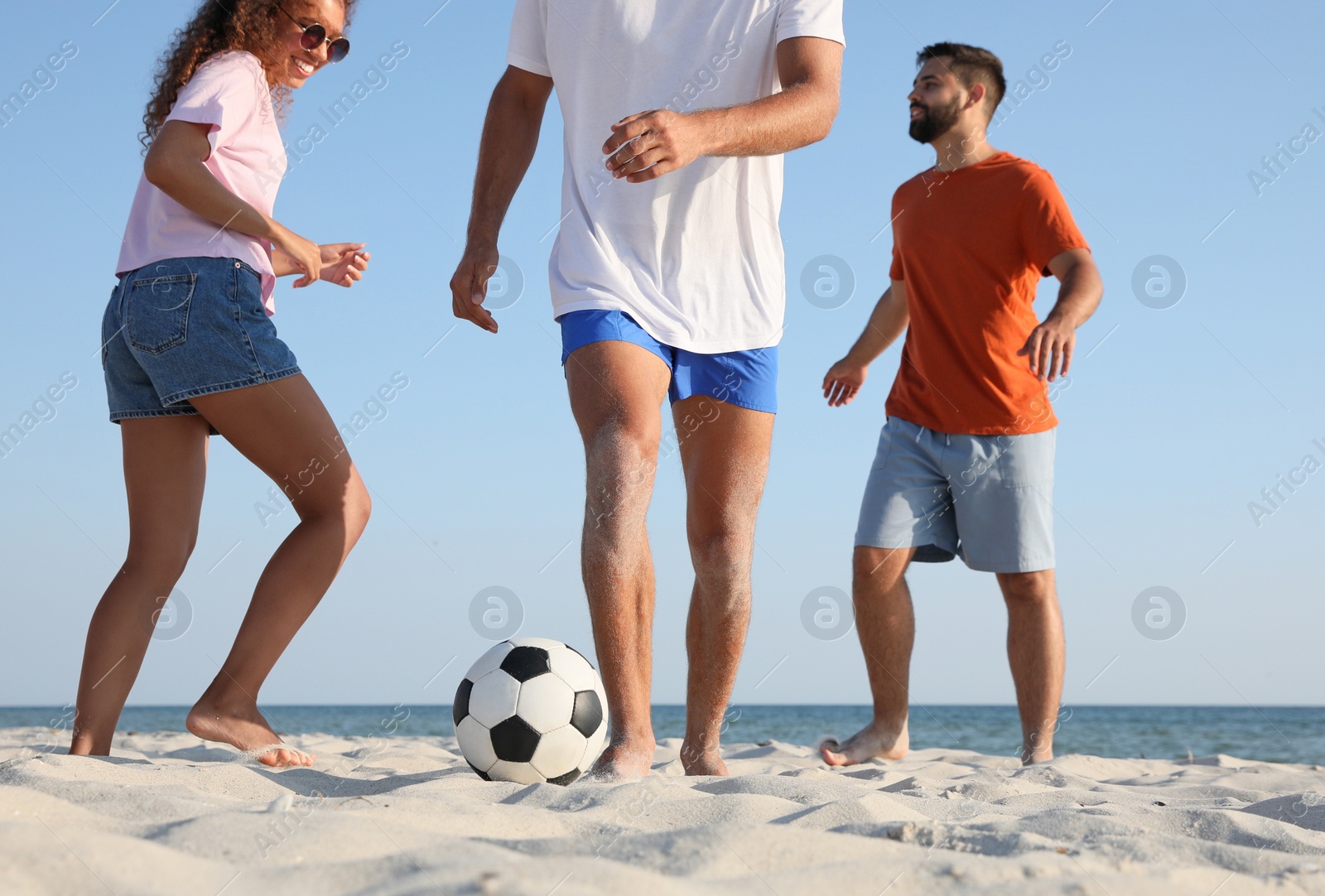 Photo of Group of friends playing football on beach