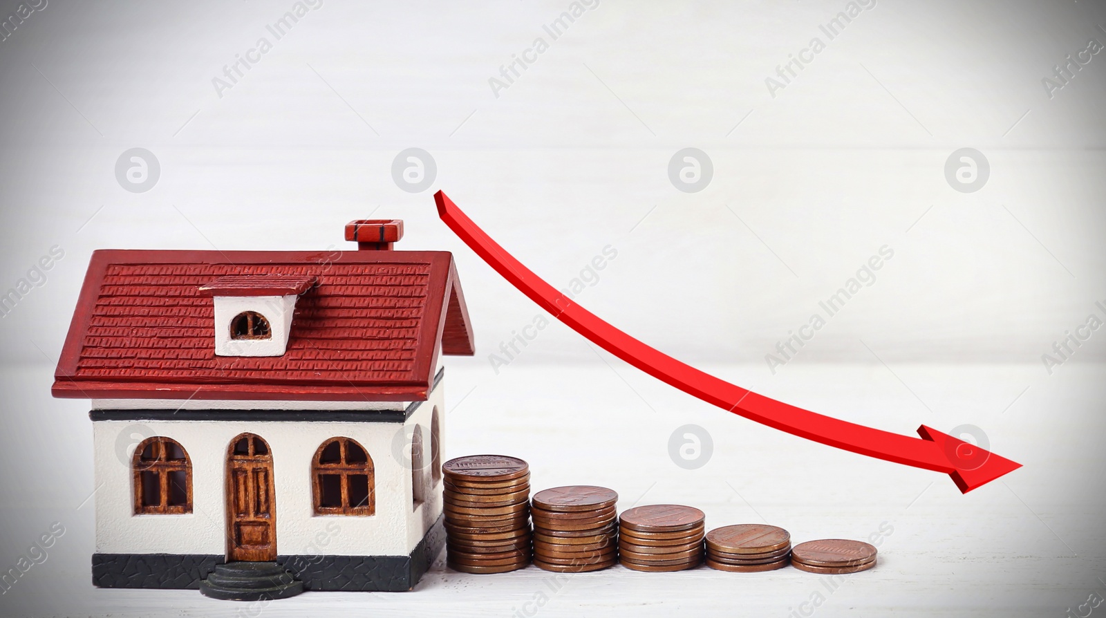 Image of Mortgage concept. House model and coins on white wooden table
