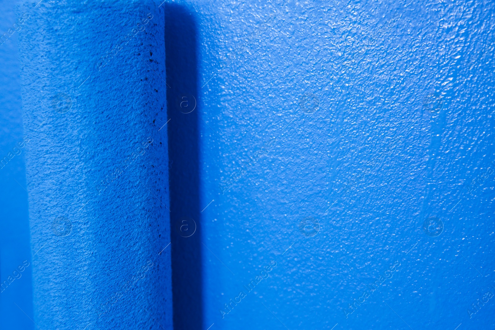 Photo of Painting wall with blue dye, closeup. Interior renovation