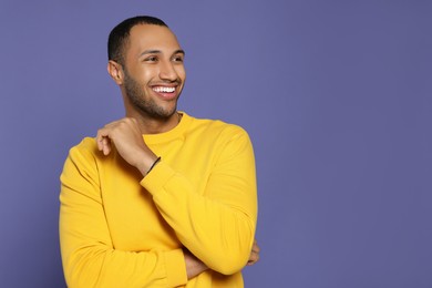 Photo of Portrait of happy African American man on purple background. Space for text