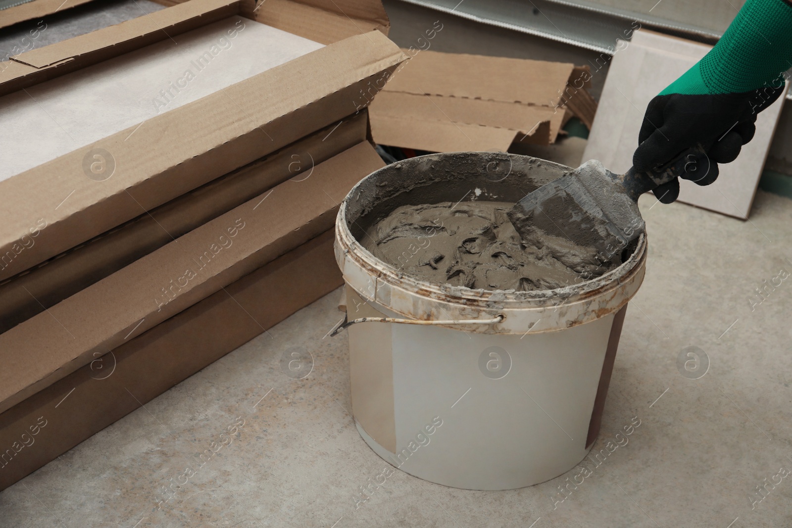 Photo of Worker taking adhesive mix with spatula, closeup