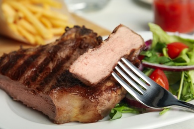 Image of Grilled steak with fresh salad on white plate, closeup