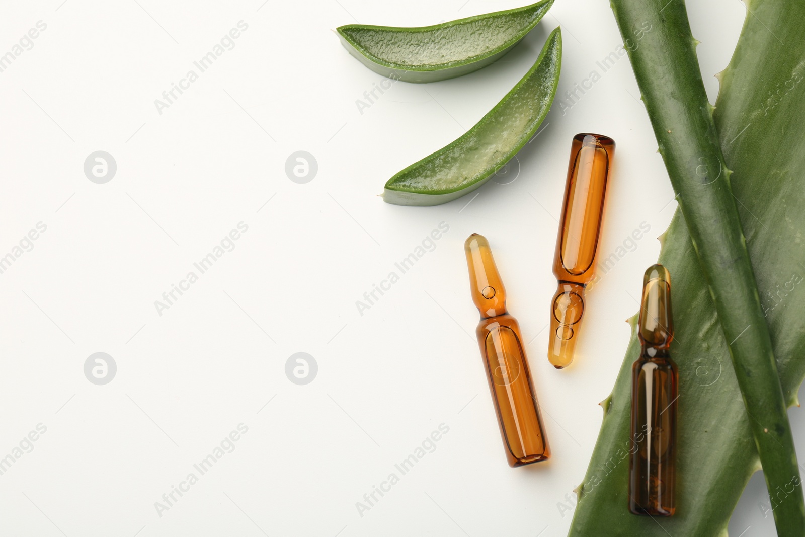 Photo of Skincare ampoules and aloe leaves on white background, flat lay. Space for text