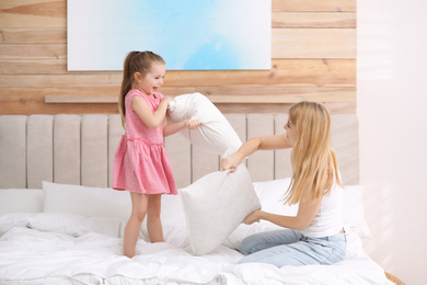 Photo of Mother playing with her child in bedroom at home